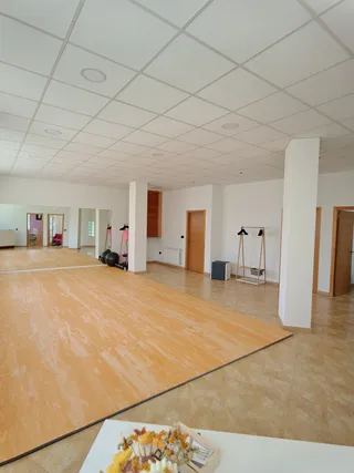 La sala grande del centro, con el suelo de madera y el espejo al fondo