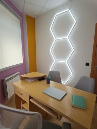 Otra de las salas del centro, con la pared magenta, la columna dorada y las luces hexagonales